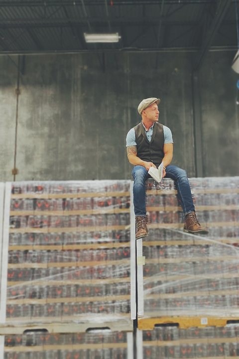 Jose sitting on pallets of product in a warehouse